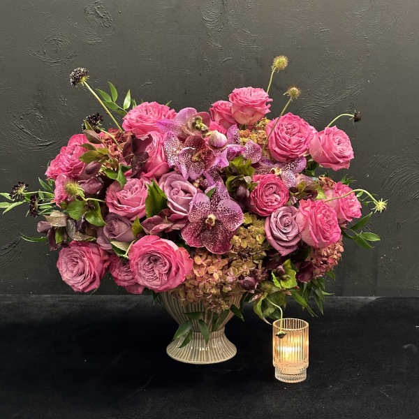 Pink rose and orchid arrangement in a ribbed vase