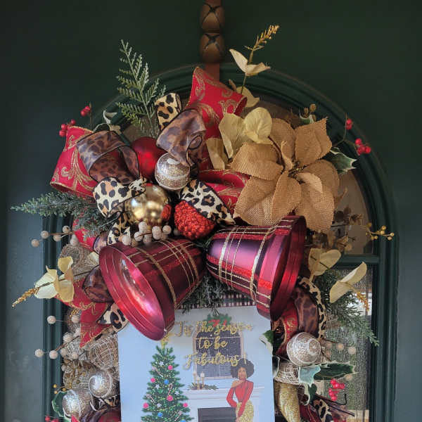 Decorated holiday wreath on a green door with ribbons and ornaments