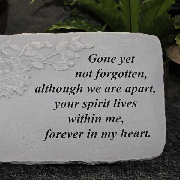 Memorial stone with engraved flower and remembrance text