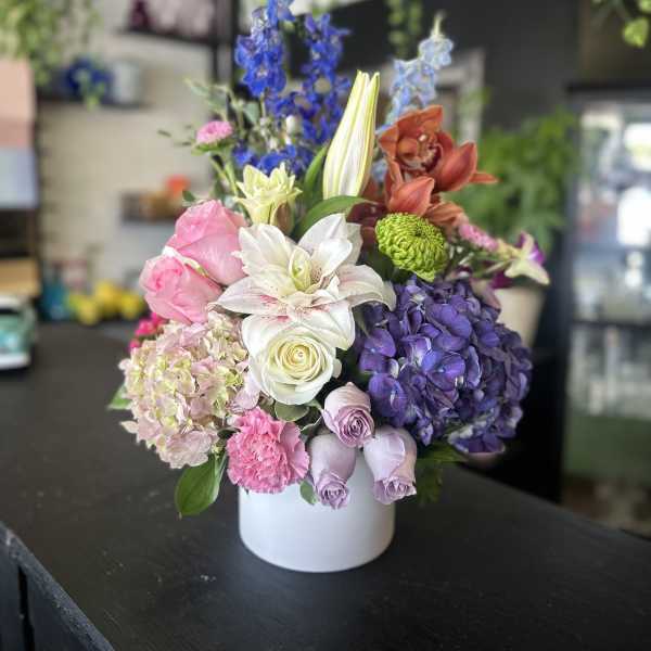 Colorful mixed flower arrangement in a white vase