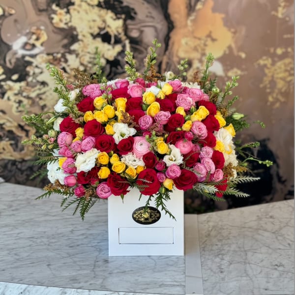 Mixed roses in pink, red, yellow, and white in a white box