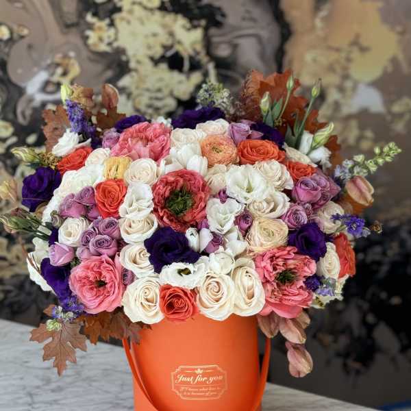 Mixed bouquet of roses and lisianthus in an orange hatbox