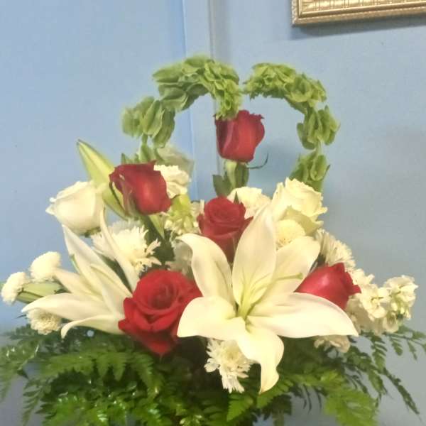 Red roses and white lilies in a red glass vase