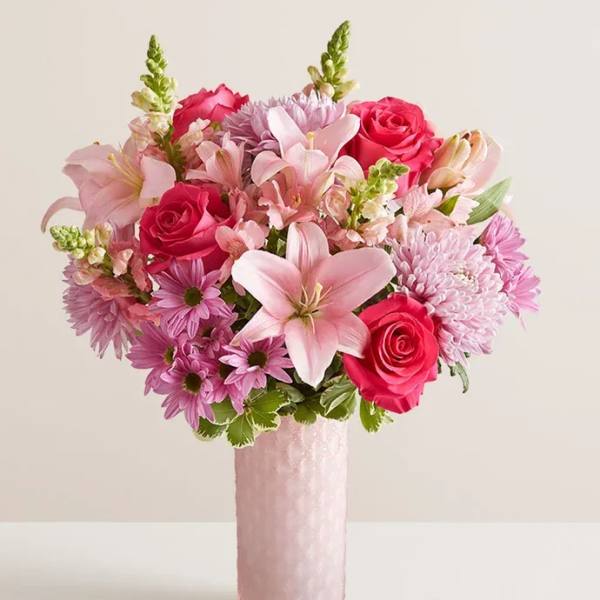 Pink bouquet of roses, lilies, and chrysanthemums in a tall vase