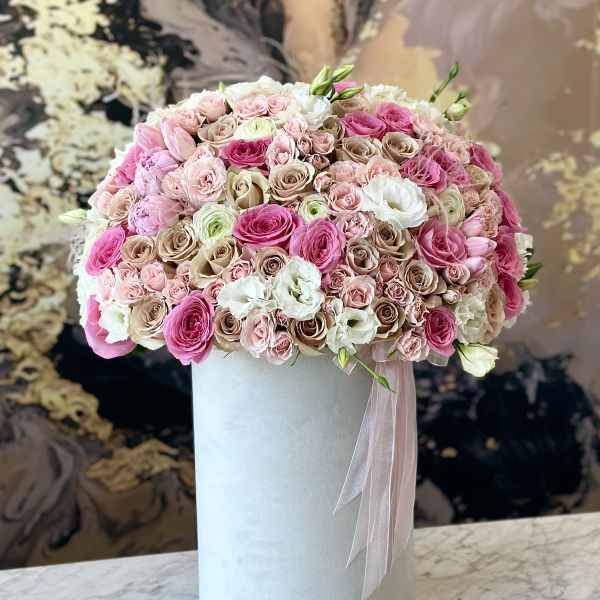 Pink and white rose arrangement in a tall white box with ribbon