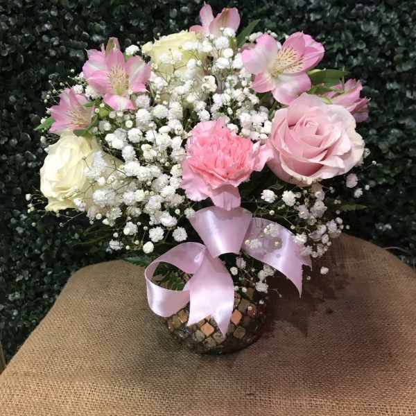 Pink and white bouquet in a mosaic vase with a pink ribbon
