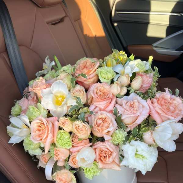 Bouquet of peach roses and white flowers in a white hat box
