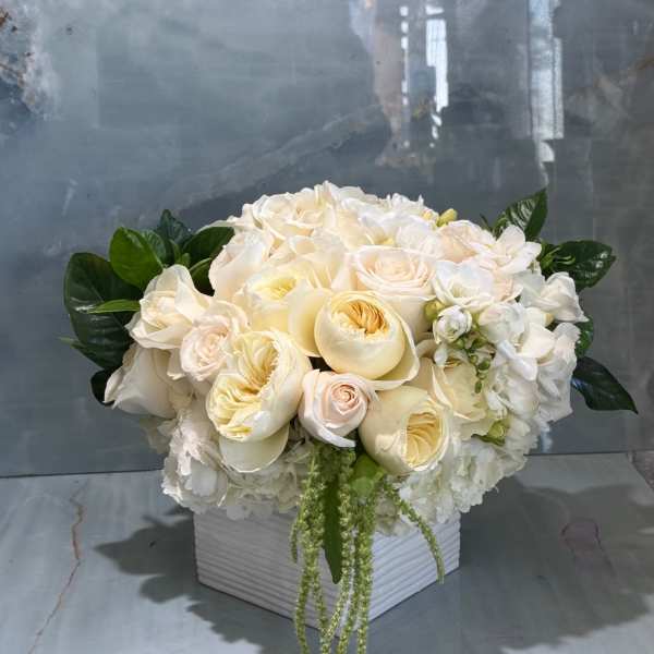 Cream and white floral arrangement in a white square vase