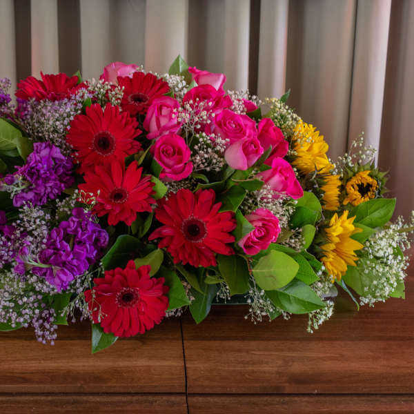 Large mixed bouquet with red gerberas, pink roses, purple flowers, and yellow sunflowers