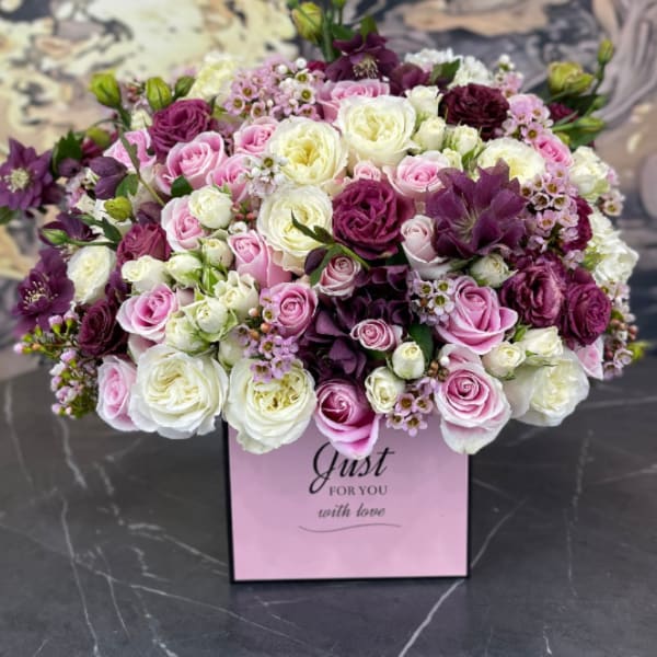 Pink, white, and purple rose bouquet in a pink gift box
