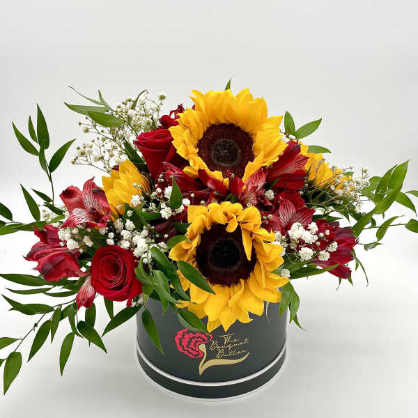 Red roses and sunflowers arranged in a round black box