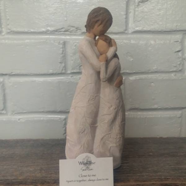 Two figurines embracing, with a small card in front