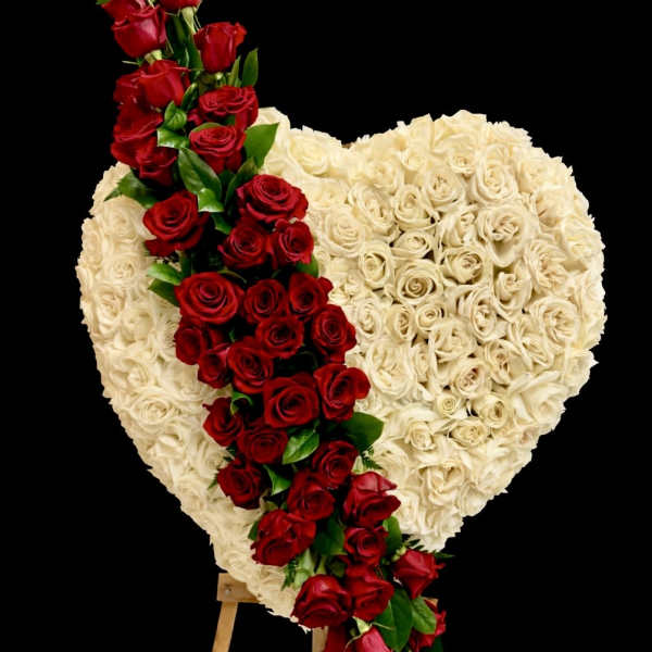Heart-shaped rose arrangement with a red rose cascade on an easel