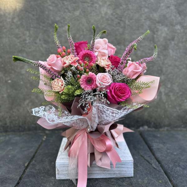 Pink mixed bouquet with roses, gerbera daisies, and carnations wrapped in ribbon
