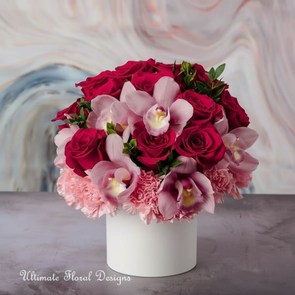 Pink roses and orchids arranged in a white vase