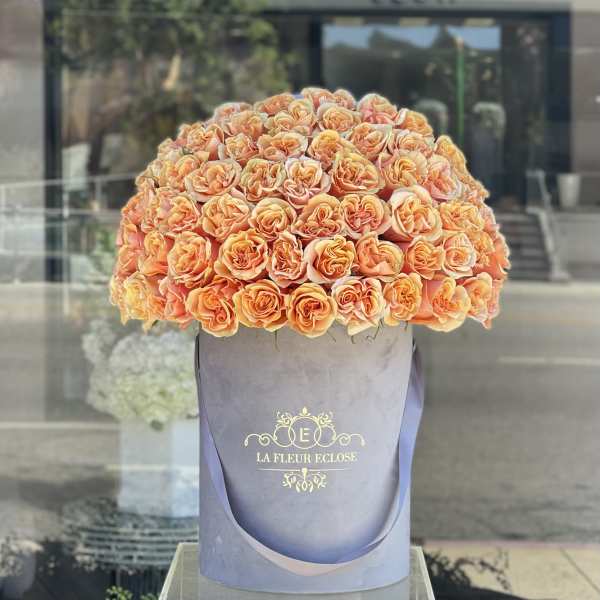 Large peach rose arrangement in a lavender hatbox