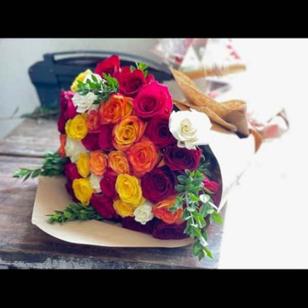 Bouquet of multicolored roses wrapped in tan paper
