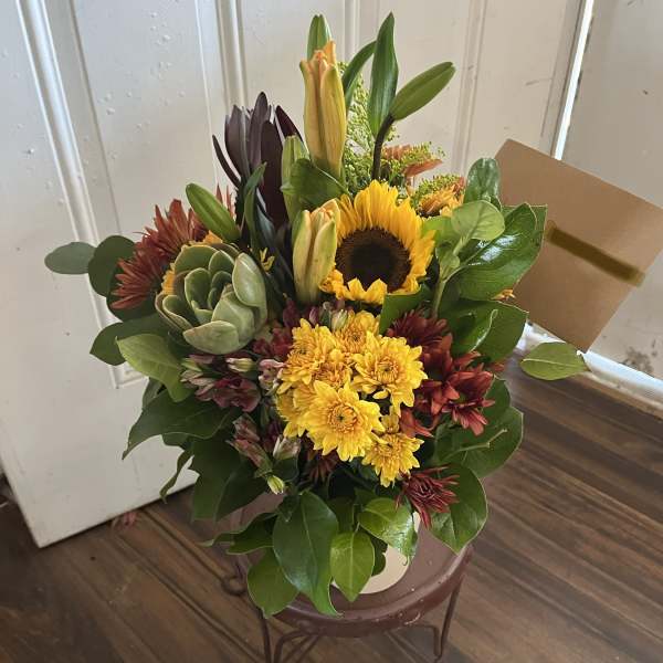 Mixed bouquet with a sunflower, yellow mums, lilies, and a succulent