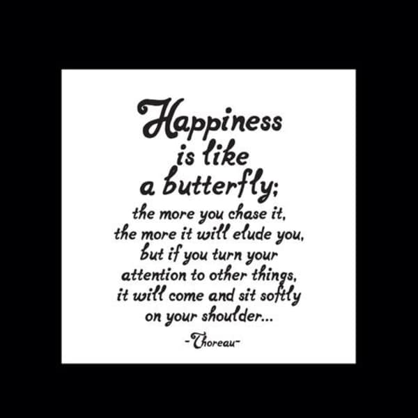 White sign with a black quote about happiness and a butterfly