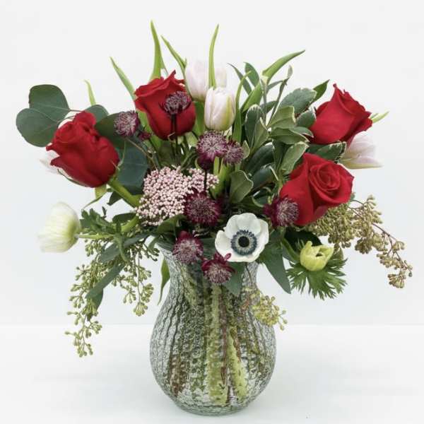 Red roses and white tulips in a glass vase