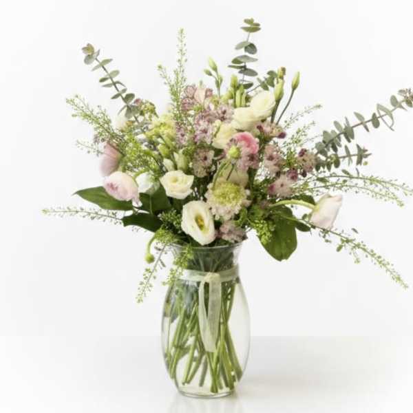 Mixed pastel bouquet in a clear glass vase with a ribbon