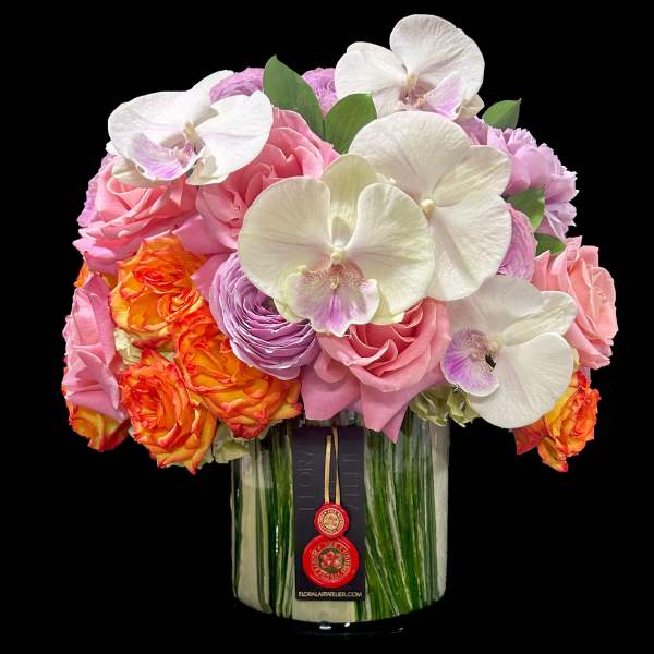 Compact arrangement of orchids and roses in a leaf-lined glass cylinder vase