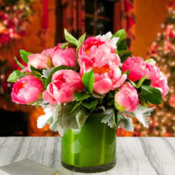 Pink peonies arranged in a green glass vase