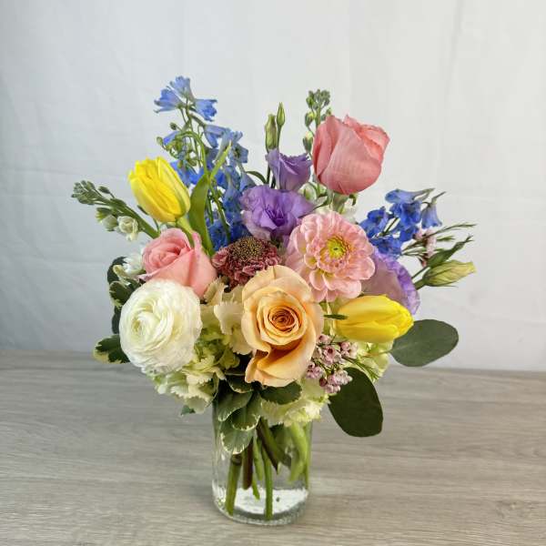 Mixed bouquet of colorful flowers in a clear glass vase