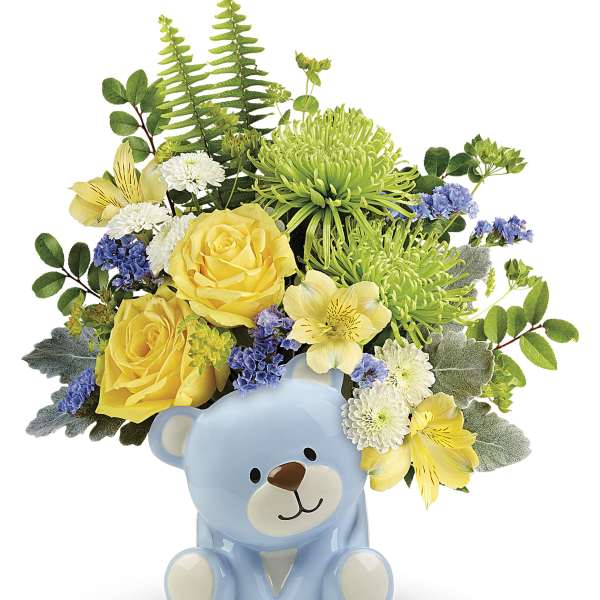 Yellow and white flowers arranged in a blue teddy bear vase