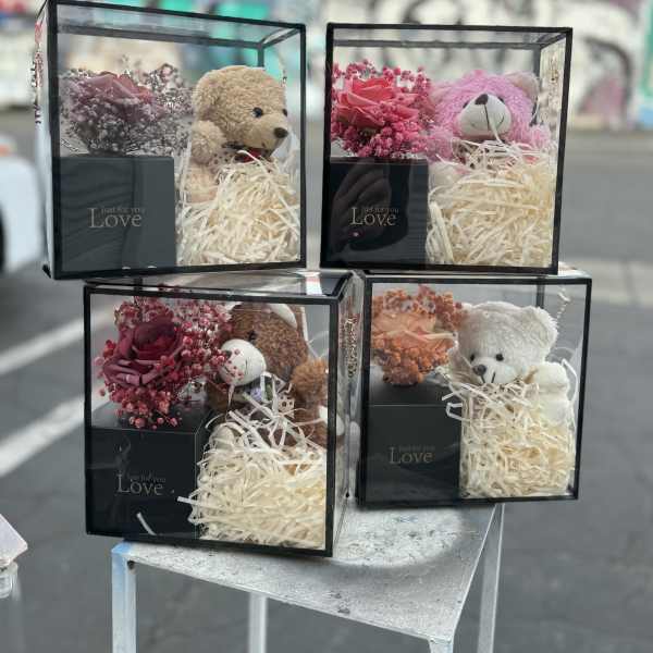 Gift boxes with teddy bears and small rose arrangements