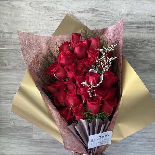 Bouquet of red roses wrapped in pink and gold paper