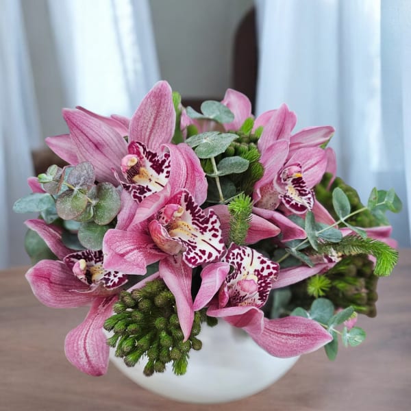 Pink orchid bouquet in a white vase