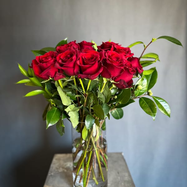 Red roses arranged in a clear glass vase