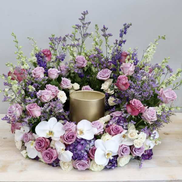 Pink and white floral wreath around a gold candle holder