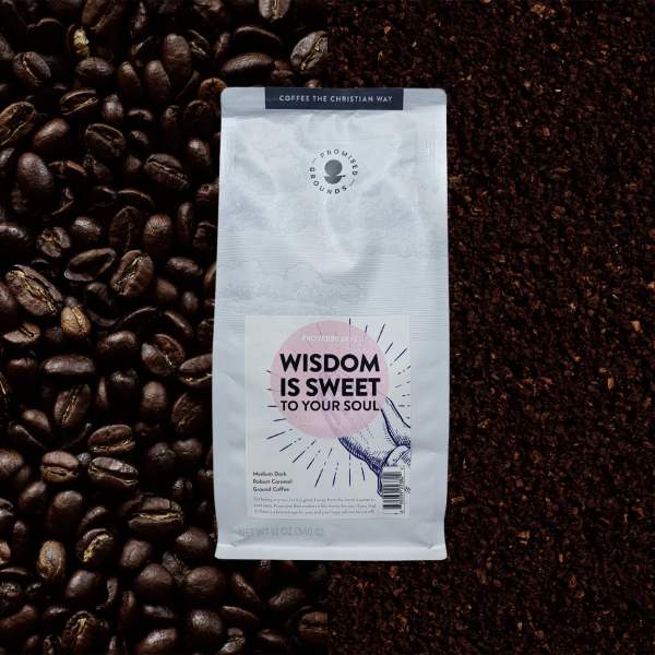 Bag of ground coffee surrounded by coffee beans