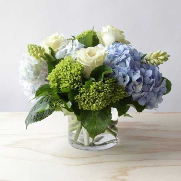 Blue and white flower arrangement in a clear glass vase