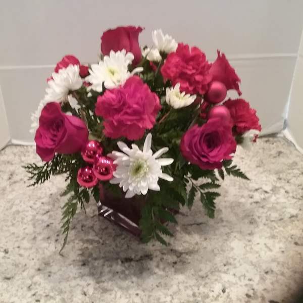 Pink and white flower arrangement in a dark vase