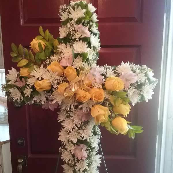 Floral cross arrangement with yellow roses and white daisies