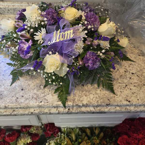 Purple and white rose bouquet with a lavender ribbon and "Mom" sign