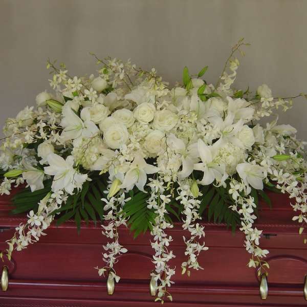 White floral casket spray with lilies and roses
