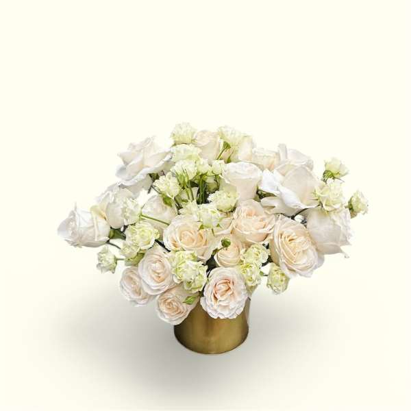 White and blush roses arranged in a gold vase