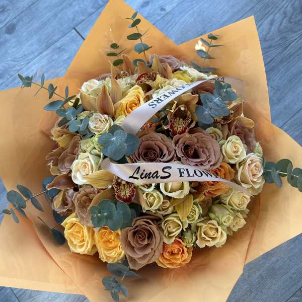 Bouquet of peach and cream roses with orchids and eucalyptus in orange wrap
