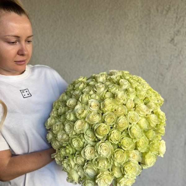 Woman holding a large bouquet of pale yellow roses