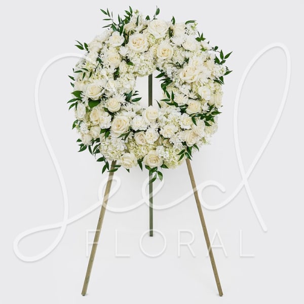 White floral wreath on a standing easel
