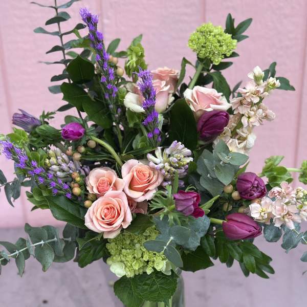 Mixed bouquet with pink roses, purple tulips, and green accents