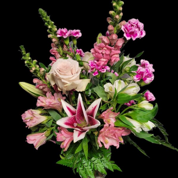 Pink and white mixed flower arrangement with a central lily in a vase