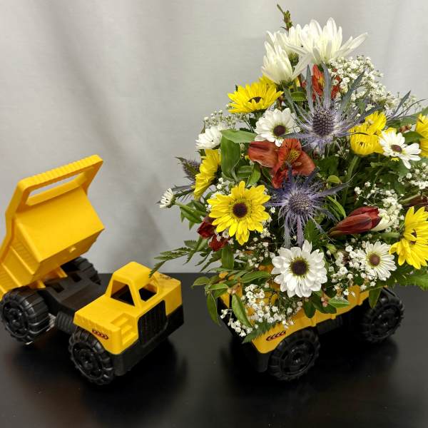 Bouquet in a yellow toy dump truck with white and yellow flowers
