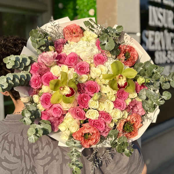 Large bouquet of pink and cream roses with green orchids and eucalyptus
