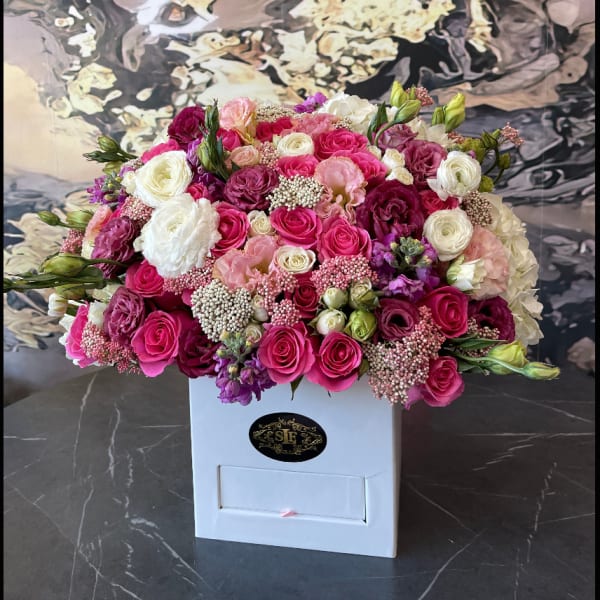 Large bouquet of pink, white, and purple roses in a white box