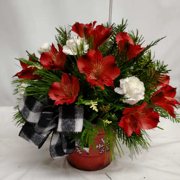 Red and white flowers arranged in a red pot with a black-and-white ribbon